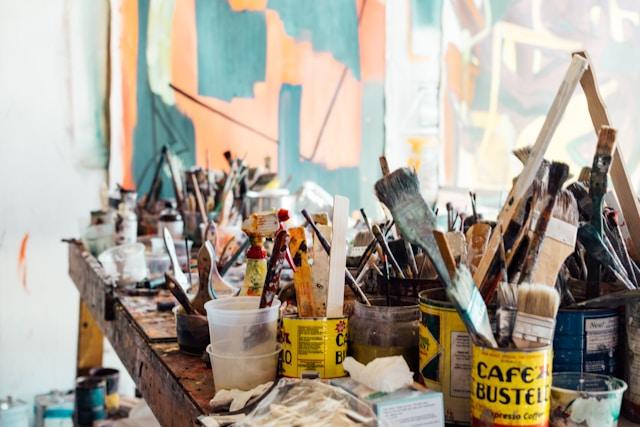 Artist desk cluttered with art supplies